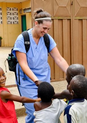 UNE Student with children in Ghana