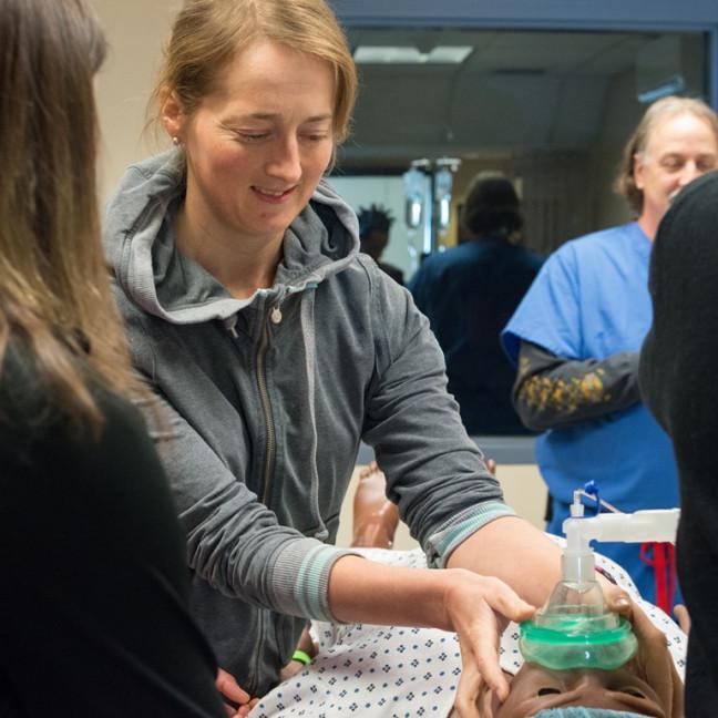 A student administers anesthesia to a simulation dummy